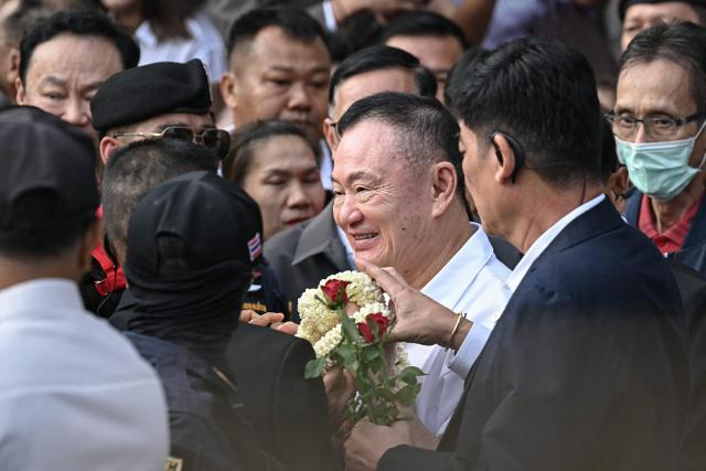 Thailand's former prime minister Thaksin Shinawatra (C) is greeted by his family members and relatives upon his release at Klong Prem Central Prison in Bangkok on May 11, 2026. Thailand's former prime minister Thaksin Shinawatra was set to be released early from prison on May 11, raising the prospect of a return to the spotlight for the political heavyweight. (Photo by Lillian SUWANRUMPHA / AFP)