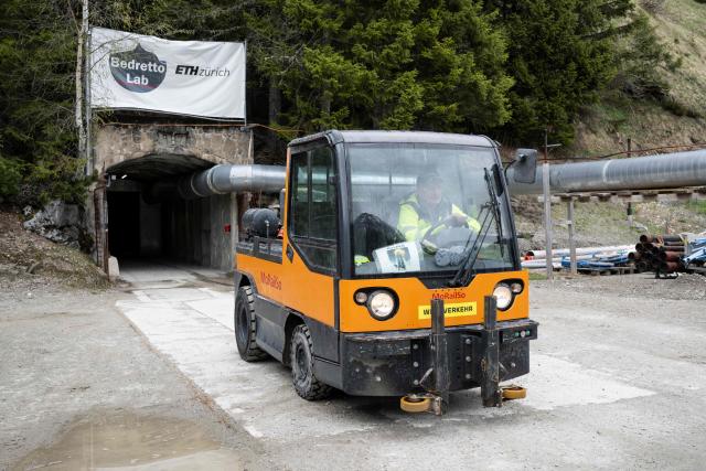 A man drives a vehicle out of the tunnel of the BedrettoLab, a unique underground research facility operated by the Federal Institute of Technology Zurich (ETH Zurich) located 1500m beneath the Swiss Alps within a 5.2 km tunnel near Bedretto, on April 29, 2026. Researchers have made the ground shake triggering thousands of tiny earthquakes in a monitored setting, as they seek to discover seismicity insights that can reduce risks. (Photo by Ennio LEANZA / AFP)