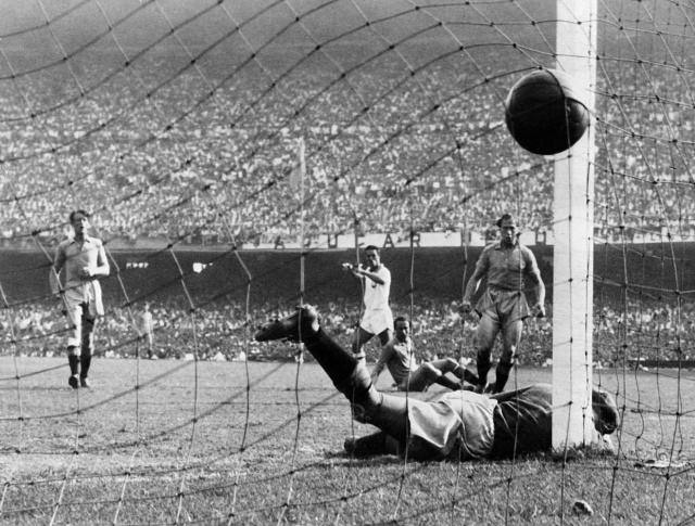(FILES) Brazilian forward Ademir (C) watches the ball go into the net as he scores his team's opening goal past Swedish goalkeeper Kalle Svensson during their World Cup final round match on July 9, 1950 at Maracana stadium in Rio de Janeiro. The world was beginning to recover from the devastation of the Second World War (1939–1945) when FIFA decided in 1946, during a congress in Luxembourg, to hold the fourth World Cup, a trophy which from that moment on came to be known as the Jules Rimet Cup in honour of the tournament’s founder. Only one country put itself forward to host the tournament: Brazil, where football had already become a national passion. The Brazilian authorities decided to impress by building the world’s largest stadium in Rio de Janeiro, the Maracana, a venue with a capacity of 200,000. (Photo by AFP)
