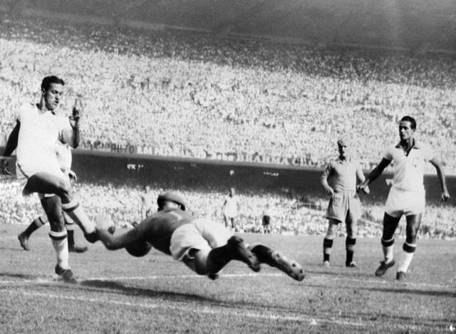 (FILES) Swedish goalkeeper Kalle Svensson dives to block the ball in front of Brazilian forward Ademir on July 9, 1950 in Rio de Janeiro during their World Cup final pool soccer match. Ademir scored four goals as Brazil beat Sweden 7-1. The world was beginning to recover from the devastation of the Second World War (1939–1945) when FIFA decided in 1946, during a congress in Luxembourg, to hold the fourth World Cup, a trophy which from that moment on came to be known as the Jules Rimet Cup in honour of the tournament’s founder. Only one country put itself forward to host the tournament: Brazil, where football had already become a national passion. The Brazilian authorities decided to impress by building the world’s largest stadium in Rio de Janeiro, the Maracana, a venue with a capacity of 200,000. (Photo by AFP)