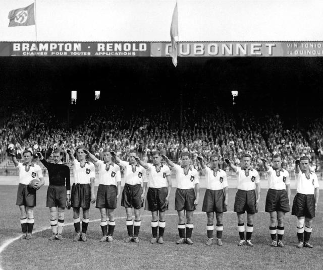(FILES) German national soccer team players execute the nazi salute, on June 4, 1938 at the Parc des Princes stadium in Paris, before the start of their World Cup match against Switzerland. (From L : Hans Mock, Rudi Raftl, Willi Schmaus, Jupp Gauchel, Rudi Gellesh, Ernst Lehner, Paul Janes, Willi Hahnemann, Anderl Kupfer, Hans Pesser, Albin Kitzinger). France hosted the 1938 World Cup against a backdrop of pre-war tensions in Europe. Austria, which had a strong national team, did not attend the tournament despite having qualified, as Adolf Hitler’s expansionist ambitions began with them. Spain did not attend either; it was ravaged by a civil war (1936–1939). (Photo by AFP)