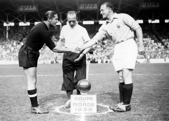 (FILES) French captains French Etienne Mattler(R)and Italian Giuseppe Meazza greet each other before the quarter-final match France - Italy of the World Cup, on June 12, 1938, at the Stade olympique Yves-du-Manoir, in Colombes. France hosted the 1938 World Cup against a backdrop of pre-war tensions in Europe. Austria, which had a strong national team, did not attend the tournament despite having qualified, as Adolf Hitler’s expansionist ambitions began with them. Spain did not attend either; it was ravaged by a civil war (1936–1939). (Photo by AFP)