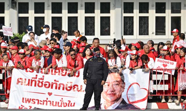 Supporters of Thailand's former prime minister Thaksin Shinawatra wait ahead of his expected release at Klong Prem Central Prison in Bangkok on May 11, 2026. Thailand's former prime minister Thaksin Shinawatra was set to be released early from prison on May 11, raising the prospect of a return to the spotlight for the political heavyweight. (Photo by ANTHONY WALLACE / AFP)