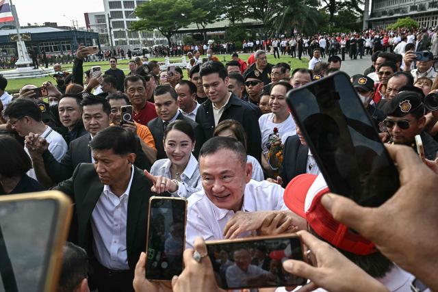 Thailand's former prime minister Thaksin Shinawatra (C) greets his supporters as he is greeted by his family members and relatives upon his release at Klong Prem Central Prison in Bangkok on May 11, 2026. Thailand's former prime minister Thaksin Shinawatra was released early from prison on May 11, raising the prospect of a return to the spotlight for the political heavyweight. (Photo by Lillian SUWANRUMPHA / AFP)