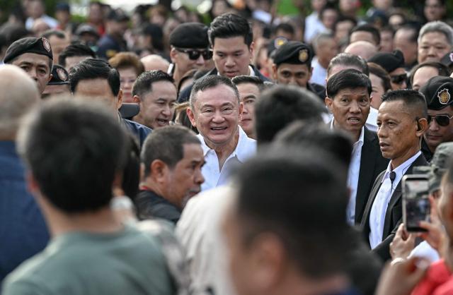 Thailand's former prime minister Thaksin Shinawatra (C) greets his supporters as he is greeted by his family members and relatives upon his release at Klong Prem Central Prison in Bangkok on May 11, 2026. Thailand's former prime minister Thaksin Shinawatra was released early from prison on May 11, raising the prospect of a return to the spotlight for the political heavyweight. (Photo by Lillian SUWANRUMPHA / AFP)