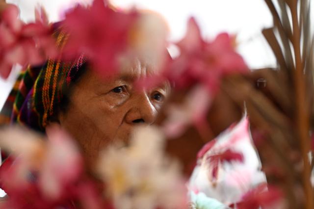 A woman decorates a palm leaf with flowers before the annual Brotherhood of Flowers and Palms festival procession in the indigenous town of Panchimalco, El Salvador, on May 10, 2026. This year, the traditional religious and cultural festivity is being held following El Salvador’s first inscription on UNESCO's Representative List of the Intangible Cultural Heritage of Humanity announced on December 10, 2025. (Photo by MARVIN RECINOS / AFP)