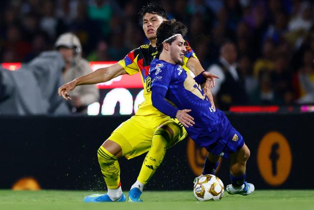 America's defender #32 Miguel Vazquez (L) and Pumas' midfielder #33 Jordan Carrillo fight for the ball during the Liga MX Clausura quarter-final second leg football match between Pumas and America at Olimpico Universitario stadium in Mexico City on May 10, 2026. (Photo by Rodrigo Oropeza / AFP)
