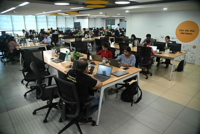 This photograph taken on April 9, 2026 shows Go Digit Insurance employees working at their office in Bengaluru. Adarsh Agarwal, appointed actuary at Go Digit, said his company has covered more than 50,000 people since it began working on parametric insurance two years ago. While still a "niche product", he said demand has increased. There is now "more knowledge and more curiosity," he told AFP, and his firm has offered both heat and air-quality parametric schemes. (Photo by Idrees MOHAMMED / AFP) / To go with 'INDIA-CLIMATE-INSURANCE, FOCUS' by Uzmi ATHAR with Aishwarya KUMAR