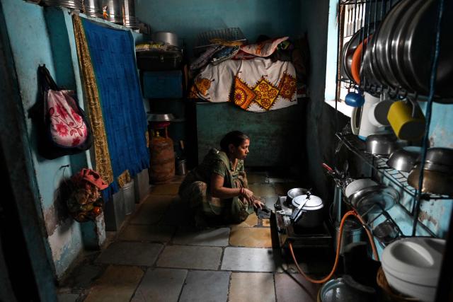 This photograph taken on April 28, 2026 shows Hasumati Parmar, a policyholder of a heat insurance scheme, preparing a meal inside her house in Ahmedabad. The scheme pays out when temperatures hit a threshold. Unlike traditional insurance, parametric policies do not require individual damage assessments. Instead, payouts are triggered automatically by heavy rain, high heat or even air pollution. (Photo by Shammi MEHRA / AFP) / To go with 'INDIA-CLIMATE-INSURANCE, FOCUS' by Uzmi ATHAR with Aishwarya KUMAR