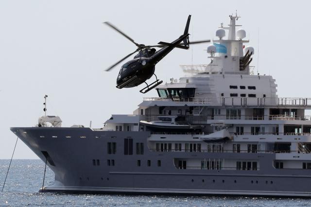(FILES) A helicopter flies by a yatch during the "Yachting Festival", a yearly yachting event which gathers 500 exhibitors on September 6, 2016 in Cannes, southeastern France. Wealthy customers, congested roads, and stunning scenery: despite growing public criticism, the French Riviera remains a thriving market for helicopter transportation, which is gearing up for the electric aircraft revolution. (Photo by VALERY HACHE / AFP)