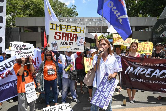 Protesters from progressive groups hold placards during a protest in support of the impeachment of Philippine Vice-President Sara Duterte in front of the Congress building in Quezon City, Metro Manila on May 11, 2026. (Photo by TED ALJIBE / AFP)
