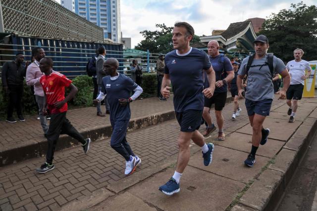 TOPSHOT - France's President Emmanuel Macron (C) jogs with Kenya's long distance runner Eliud Kipchoge (CL) past the University of Nairobi ahead of the Africa Forward summit in Nairobi on May 11, 2026. (Photo by Ludovic MARIN / AFP)
