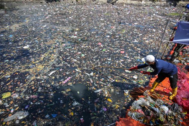 Activists from ECOTON (Ecological Observation and Wetland Conservations) and workers from the city government’s Environmental Agency clean trash from the Kali Tebu River in Surabaya, Indonesia's East Java province, on May 11, 2026. (Photo by JUNI KRISWANTO / AFP)