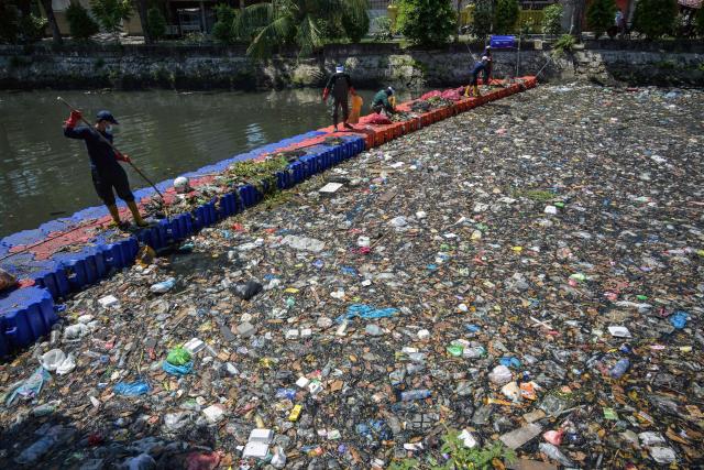Activists from ECOTON (Ecological Observation and Wetland Conservations) and workers from the city government’s Environmental Agency clean trash from the Kali Tebu River in Surabaya, Indonesia's East Java province, on May 11, 2026. (Photo by JUNI KRISWANTO / AFP)