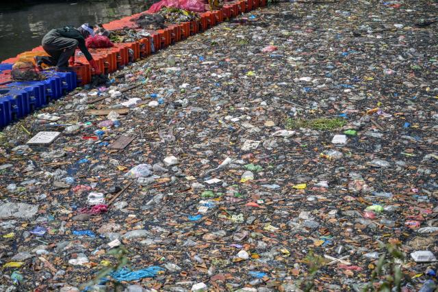 Activists from ECOTON (Ecological Observation and Wetland Conservations) and workers from the city government’s Environmental Agency clean trash from the Kali Tebu River in Surabaya, Indonesia's East Java province, on May 11, 2026. (Photo by JUNI KRISWANTO / AFP)