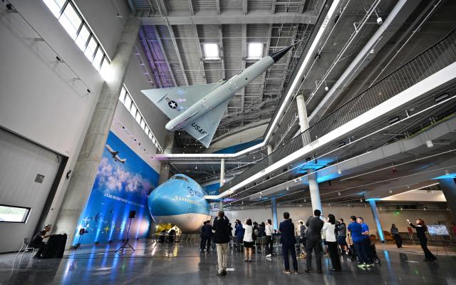People gather for a press preview of the Korean Air Aviation Gallery inside the future Samuel Oschin Air and Space Center at the California Science Center in Los Angeles, California, on May 12, 2026, following the installation of the first artifacts in the gallery, including a Convair F-106 Delta Dart displayed above a Korean Air Boeing 747 on the ground level. (Photo by Frederic J. BROWN / AFP)