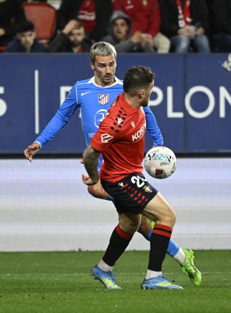 Atletico Madrid's French forward #07 Antoine Griezmann fights for the ball with Osasuna's Spanish midfielder #20 Javi Galan during the Spanish league football match between CA Osasuna and Club Atletico de Madrid at El Sadar Stadium in Pamplona on May 12, 2026. (Photo by ANDER GILLENEA / AFP)