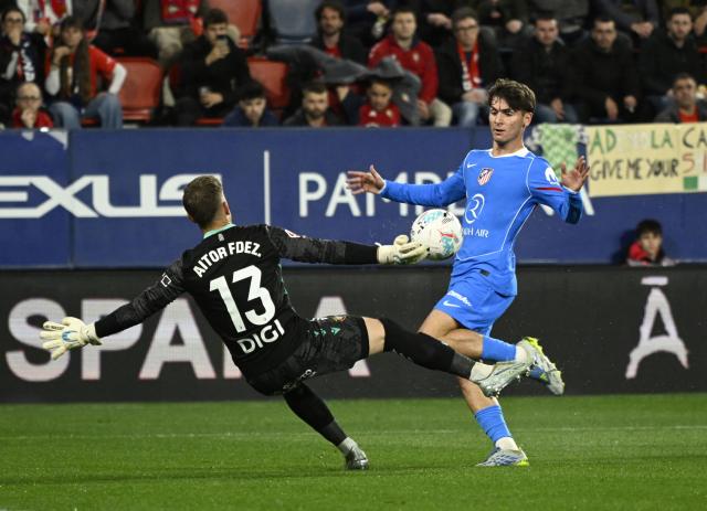Atletico Madrid's Spanish midfielder #04 Rodrigo Mendoza challenges Osasuna's Spanish goalkeeper #13 Aitor Fernandez during the Spanish league football match between CA Osasuna and Club Atletico de Madrid at El Sadar Stadium in Pamplona on May 12, 2026. (Photo by ANDER GILLENEA / AFP)