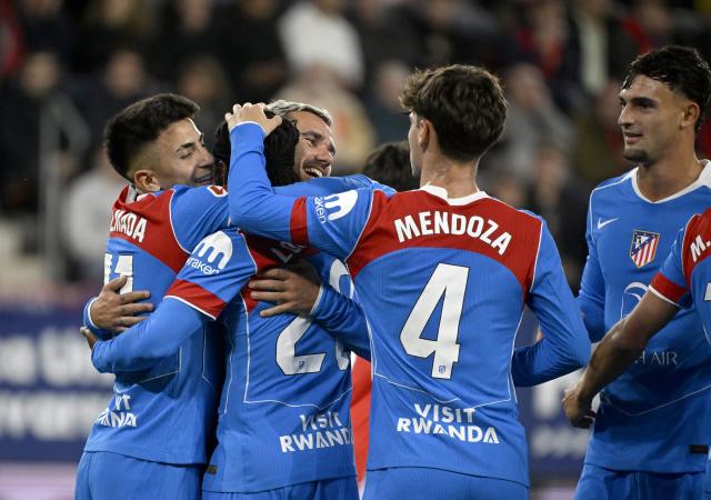 Atletico Madrid's English forward #22 Ademola Lookman celebrates with teammates scoring his team's first goal from the penalty spot during the Spanish league football match between CA Osasuna and Club Atletico de Madrid at El Sadar Stadium in Pamplona on May 12, 2026. (Photo by ANDER GILLENEA / AFP)