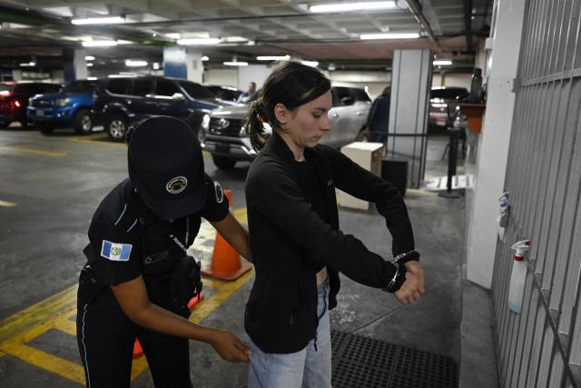 A guard of the Penitentiary System searches US citizen Kayla Barry, 31, before her court hearing at the Palace of Justice in Guatemala City on May 12, 2026. A US citizen woman was apprehended on May 12 at the airport in the Guatemalan capital as she tried to enter the country with heroin and marijuana hidden in hundreds of bags of candy, according to the police and the prosecutor’s office. (Photo by Johan ORDУСEZ / AFP)