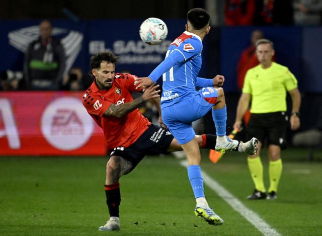 Osasuna's Spanish forward #14 Ruben Garcia Santos fights for the ball with Atletico Madrid's Argentine midfielder #11 Thiago Almada during the Spanish league football match between CA Osasuna and Club Atletico de Madrid at El Sadar Stadium in Pamplona on May 12, 2026. (Photo by ANDER GILLENEA / AFP)
