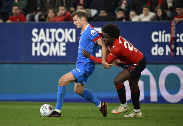 Atletico Madrid's Norwegian forward #09 Alexander Sorloth fights for the ball with Osasuna's Cameroonian defender #22 Flavien Boyomo during the Spanish league football match between CA Osasuna and Club Atletico de Madrid at El Sadar Stadium in Pamplona on May 12, 2026. (Photo by ANDER GILLENEA / AFP)