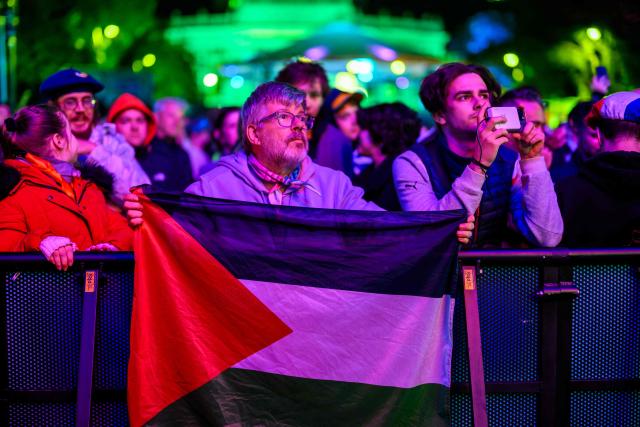 A fan displays a Palestinian flag at the fan area at City Hall Square (Rathausplatz) during the first semi-final of the Eurovision Song Contest (ESC) in Vienna, Austria on May 12, 2026. (Photo by MAX SLOVENCIK / APA / AFP) / Austria OUT