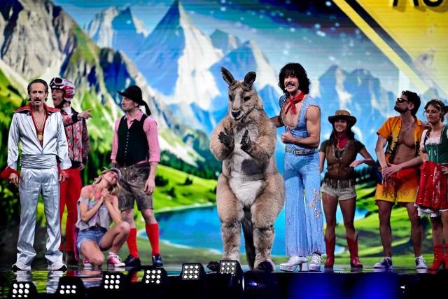 Australia's Marty Joe Zambotto aka Go-Jo (R), who represented Australia in the 2025 ESC, and Austrian presenters Victoria Swarovski (not pictured) and Michael Ostrowski (L) perform a song on the differences between Austria and Australia, during the first semi-final of the Eurovision Song Contest 2026 (ESC) at Wiener Stadthalle in Vienna, Austria on May 12, 2026. (Photo by Tobias SCHWARZ / AFP)