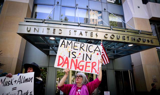 AI protesters chant outside the federal courthouse during proceedings in the trial of Elon Musk VS. OpenAI in Oakland, California, on May 12, 2026. Musk, the founder of Tesla and SpaceX, alleges that Altman and co-founder Greg Brockman misappropriated his $38 million donations when OpenAI abandoned its original nonprofit and philanthropic mission to become the for-profit giant behind ChatGPT. (Photo by JOSH EDELSON / AFP)