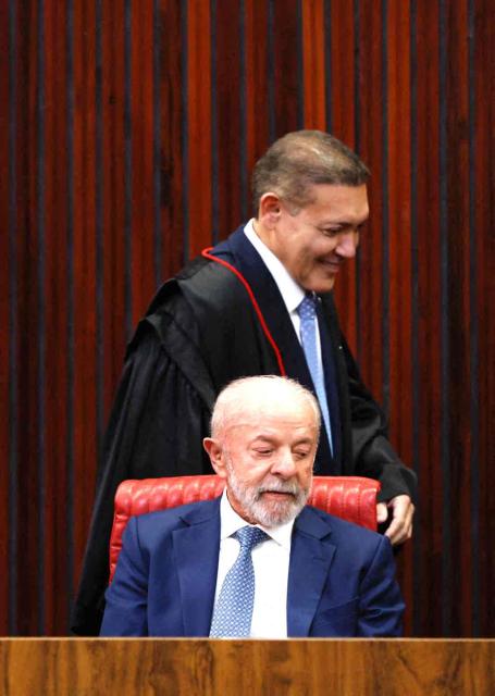 Brazil's President Luiz Inacio Lula da Silva (C) and Judge Nunes Marques, President of the Superior Electoral Court (TSE), reacts during Nunes's swearing-in ceremony in Brasilia on May 12, 2026. (Photo by Sergio LIMA / AFP)
