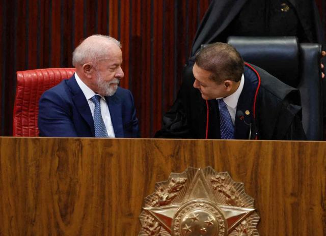 Brazil's President Luiz Inácio Lula da Silva (L) speaks with Judge Nunes Marques, President of the Superior Electoral Court (TSE), during Nunes's swearing-in ceremony in Brasília on May 12, 2026. (Photo by Sergio LIMA / AFP)