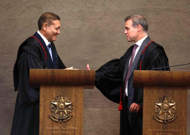 The new Vice President of the Superior Electoral Court, Minister Andre Mendonca, shakes hands with Judge Nunes Marques, President of the Superior Electoral Court (TSE), during Nunes's swearing-in ceremony in Brasilia on May 12, 2026. (Photo by Sergio LIMA / AFP)