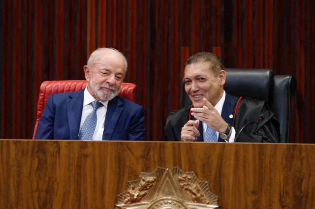 Brazil's President Luiz Inacio Lula da Silva (L) speaks with Judge Nunes Marques, President of the Superior Electoral Court (TSE), during Nunes's swearing-in ceremony in Brasilia on May 12, 2026. (Photo by Sergio LIMA / AFP)