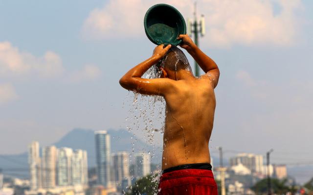 A boy cools off during a heatwave in Tegucigalpa City on May 12, 2026. Honduras has decided to shorten the school-day and hold virtual classes due to the high temperatures that could intensify due to El Nino phenomenon, official sources reported. (Photo by Johny MAGALLANES / AFP)