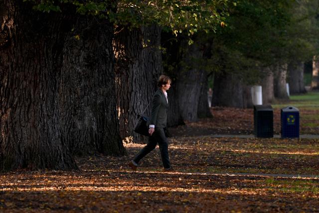 A man walks to work on a cool autumn morning in Melbourne's Fitzroy Gardens on May 13, 2026. (Photo by William WEST / AFP)