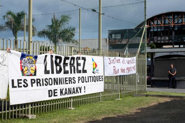 A banner calling for the release of political prisoners is pictured as pro-independence activists and supporters take part in a demonstration to mark the second anniversary of the spring 2024 riots in Noumea, in the French overseas collectivity of New Caledonia, on May 13, 2026. Two years after the violence that left 14 dead and caused several billion euros’ worth of damage in New Caledonia, tensions and mistrust remain, as the debate over the electoral roll, which sparked the insurrectional crisis, is still unresolved. (Photo by Delphine MAYEUR / AFP)