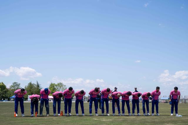 In this photo taken on May 9, 2026, members of the Japanese cricket team bow to fans after they won their ICC T20 World Cup East Asia-Pacific Qualifier match against Vanuatu at the Nisshin Cricket Ground at Korogi Sports Park in Nisshin, Aichi Prefecture. Curious spectators clutching rulebooks watch as a batsman smacks a six into the sand and weeds surrounding Japan's brand-new cricket ground, four months before it hosts matches at the Asian Games. (Photo by Andrew CABALLERO-REYNOLDS / AFP) / To go with 'ASIAD-2026-CRICKET-JPN,FOCUS' by Andrew MCKIRDY