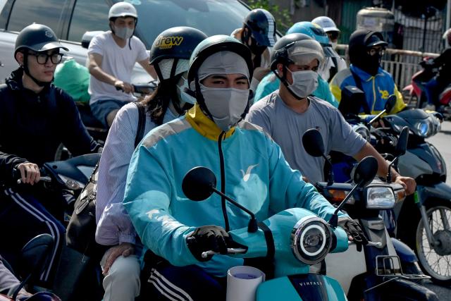 People ride motorbikes and scooters along a street in Hanoi on May 13, 2026. (Photo by Nhac NGUYEN / AFP)