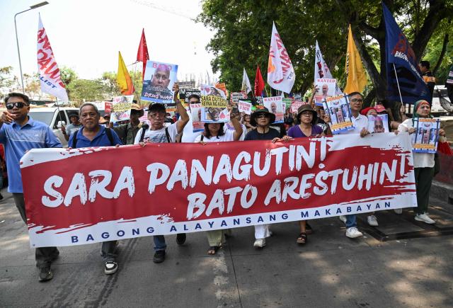 Protesters carrying a banner reading "Sara (Philippine Vice President Sara Duterte) take responsibility, arrest Bato" (the nickname of Senator Ronald dela Rosa) march towards the Senate in Manila on May 13, 2026. Former Philippine leader Rodrigo Duterte's top drug war enforcer said he would never surrender to an international court, while pleading for current President Ferdinand Marcos to intervene on his behalf. (Photo by TED ALJIBE / AFP)