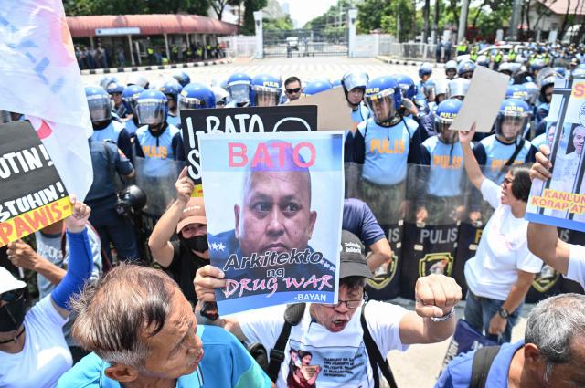 Protesters hold placards featuring Senator Ronald dela Rosa during a protest in front the Senate in Manila on May 13, 2026. Former Philippine leader Rodrigo Duterte's top drug war enforcer said he would never surrender to an international court, while pleading for current President Ferdinand Marcos to intervene on his behalf. (Photo by TED ALJIBE / AFP)