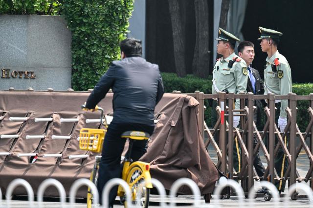 Chinese paramilitary police stand guard next a hotel where US President Donald Trump is set to stay in Beijing on May 13, 2026, ahead of the US leader's arrival. (Photo by Hector RETAMAL / AFP)