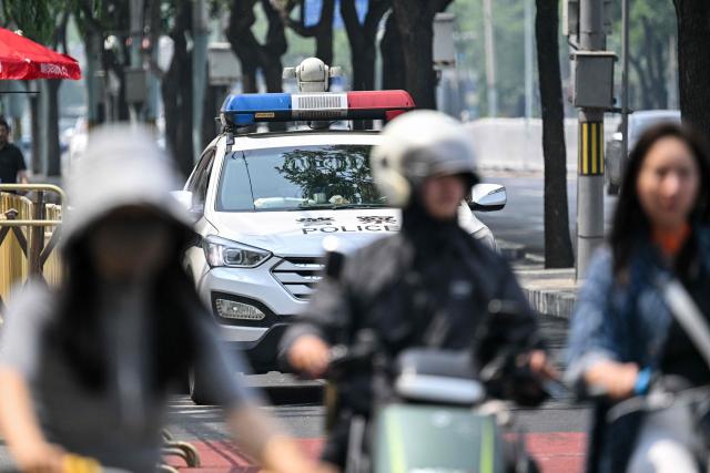 A police car is seen around the perimeter of a hotel where US President Donald Trump is set to stay in Beijing on May 13, 2026, ahead of the US leader's arrival. (Photo by Hector RETAMAL / AFP)