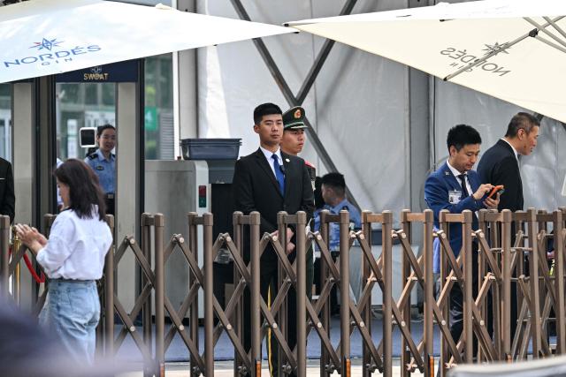 Security guards are seen around the perimeter of a hotel where US President Donald Trump is set to stay in Beijing on May 13, 2026, ahead of the US leader's arrival. (Photo by Hector RETAMAL / AFP)