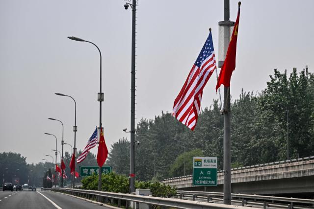 The national flags of the United States and China hang on a highway, on May 13, 2026, ahead of a visit by US President Donald Trump. (Photo by Pedro PARDO / AFP)