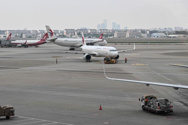 China Eastern Airlines aircraft are pictured at the Shanghai Hongqiao International Airport in Shanghai on May 12, 2026. (Photo by Hector RETAMAL / AFP)