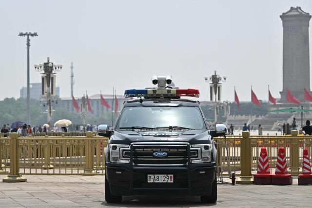 A police vehicle is seen on Tiananmen Square in Beijing on May 13, 2026, ahead of a visit by US President Donald Trump. (Photo by Pedro PARDO / AFP)