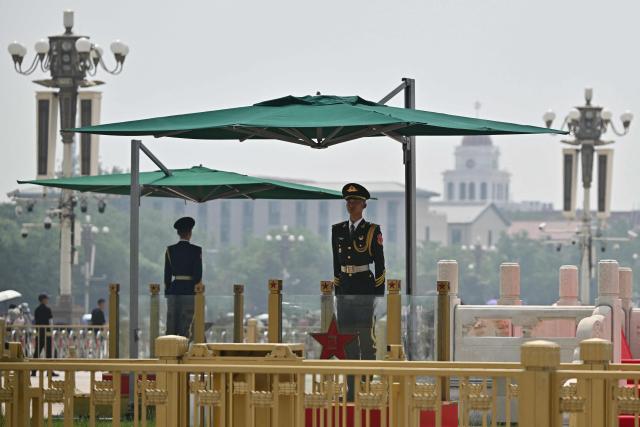 Chinese paramilitary police officers stand guard on Tiananmen Square in Beijing on May 13, 2026, ahead of a visit by US President Donald Trump. (Photo by Pedro PARDO / AFP)