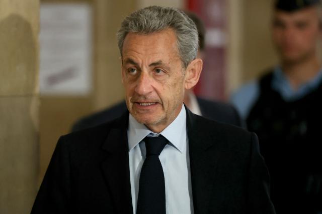 France's former president Nicolas Sarkozy arrives for his appeal trial over charges he had sought Libyan financing for his 2007 election in exchange for helping improve Tripoli's image after deadly bombing, at the Palais de Justice courthouse in Paris on May 13, 2026. Nearly two months after the start of the appeal trial regarding allegations of Libyan funding of Nicolas Sarkozy's 2007 presidential campaign, the public prosecutor's office is due to announce on May 13, 2026, the sentences it is seeking against Nicolas Sarkozy and his nine co-defendants, in this case that has already seen the former head of state serve time in prison. (Photo by Alain JOCARD / AFP)