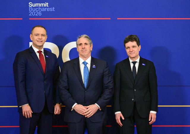Romania's President Nicusor Dan (R) and Poland's President Karol Nawrocki (L) pose with US Under Secretary of State for Arms Control and International Security Thomas DiNanno before attending the summit of the Bucharest Nine (B9) and the Nordic countries at the Cotroceni Palace in Bucharest, Romania on May 13, 2026. The event is co-chaired by the President of Romania and the President of Poland under the overarching theme of 'Delivering More for Transatlantic Security' and will focus on transatlantic security and NATOs forthcoming summit in Ankara. The B9 format, also known as NATO's Eastern Flank, includes Bulgaria, the Czech Republic, Estonia, Hungary, Latvia, Lithuania, Poland, Romania and Slovakia. (Photo by Daniel MIHAILESCU / AFP)