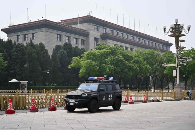 A police vehicle is pictured near the Great Hall of the People in Beijing on May 13, 2026, ahead of a visit by US President Donald Trump. (Photo by Pedro PARDO / AFP)